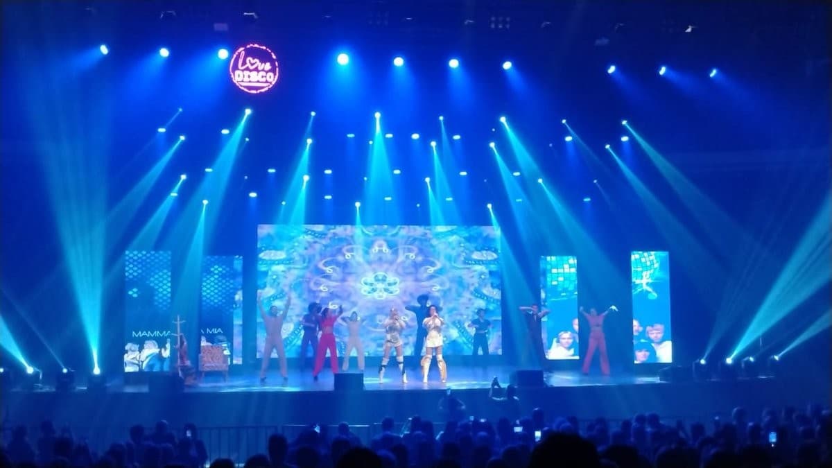Palco com painel de LED de grande formato durante espetáculo na Araújo Vianna, plateia em primeiro plano.