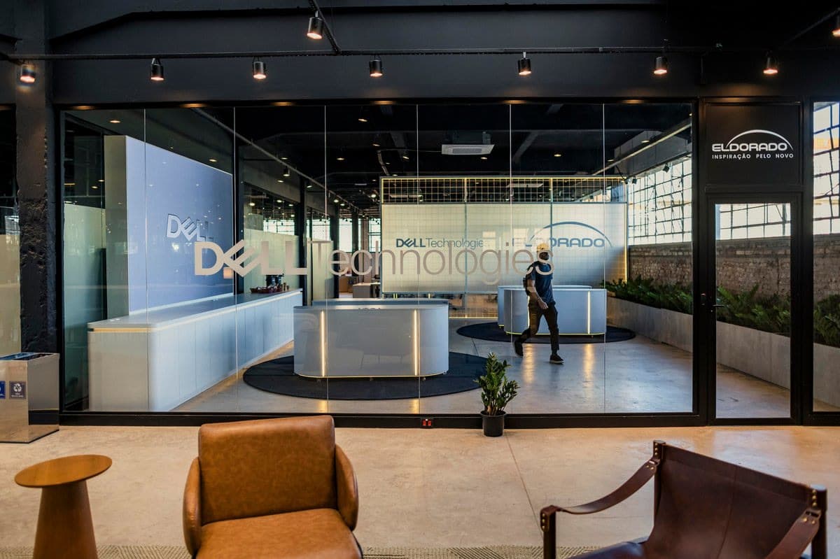 Vista ampla da recepção Dell Technologies no Instituto Caldeira, integrando o painel de LED ao ambiente construído.