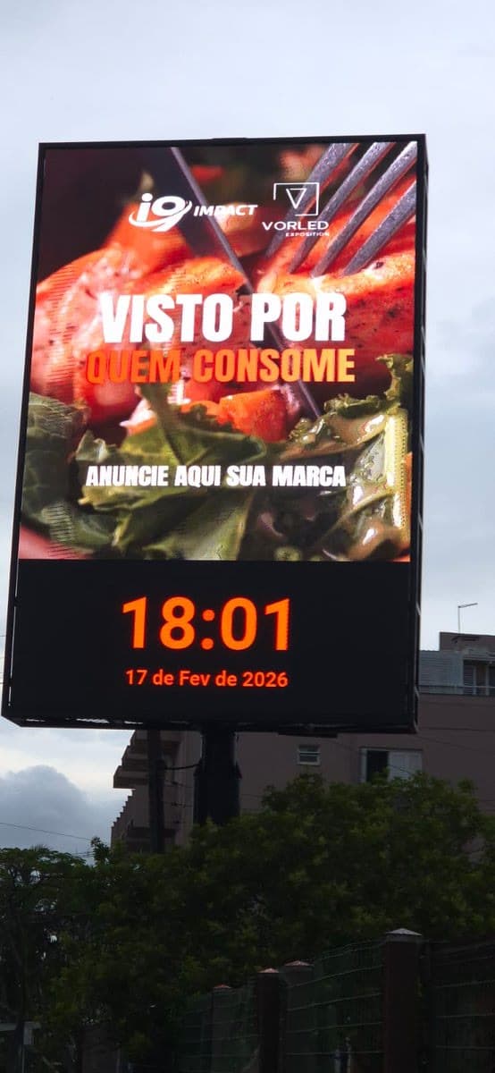 Painel de LED da I9 Mídia exibindo campanha publicitária ativa, com data e hora reais sobrepostas ao conteúdo.
