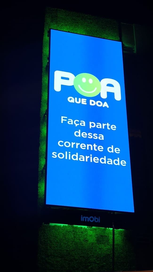 Empena de LED da Imobi em operação noturna, exibindo campanha de responsabilidade social.
